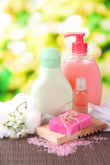 Obraz na płótnie Canvas Cosmetics bottles and natural handmade soap on green background