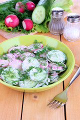 Vitamin vegetable salad in bowl on wooden table close-up