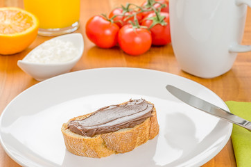 Baguette mit Haselnusscreme auf einem gedeckten Frühstückstisch