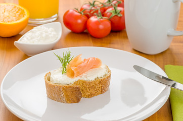 Baguette mit Lachs auf einem gedeckten Frühstückstisch