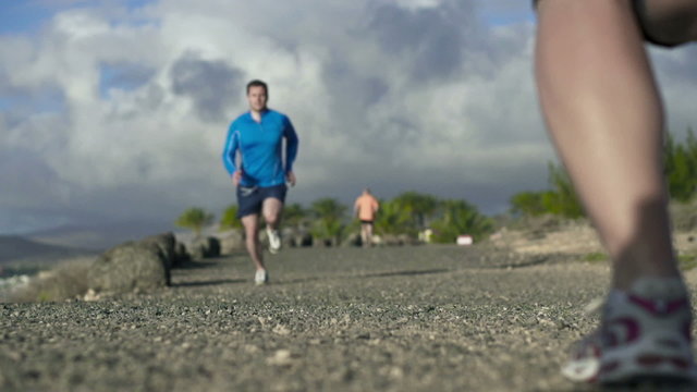 Young couple jogging on the beach, slow motion shot at 120fps 