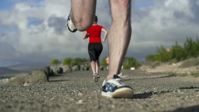 Young couple jogging on the beach, slow motion shot at 240fps 