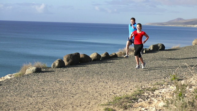 Young couple jogging on the beach, slow motion shot at 60fps 