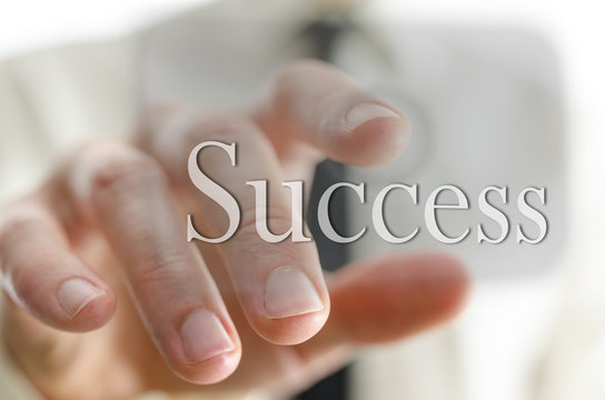 Businessman pointing at success icon on a virtual screen