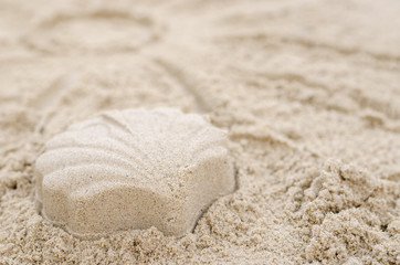 Fototapeta na wymiar Shell made of sand on a sandy beach