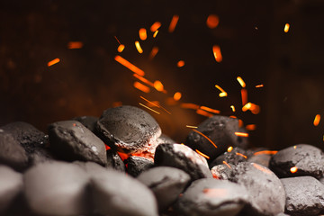 Charcoal briquettes with fire sparks.