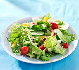 Deurstickers garden salad with fresh vegetables on blue table cloth © Joshua Resnick