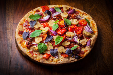 Homemade pizza with dried tomatoes and salami