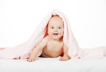Caucasian baby boy covered with pink towel joyfully smiles at ca