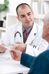 Smiling doctor giving a prescription