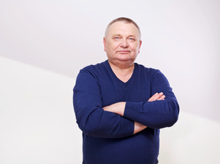 Portrait of senior man in jumper over white