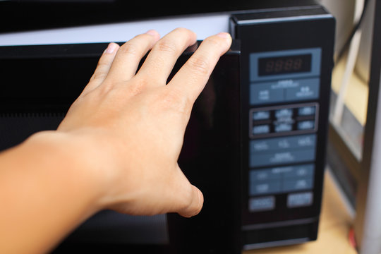 Hand using microwave oven