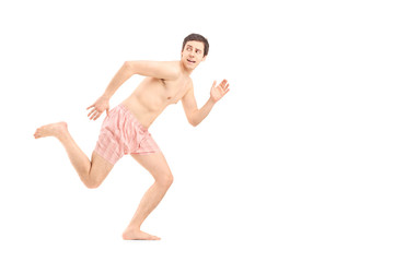 An embarrassed naked man in underwear running away