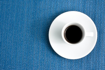 dark espresso in a cup on blue texture