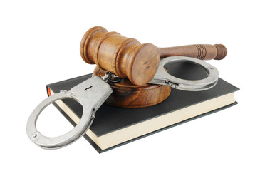 Judge's gavel and handcuffs on black legal book