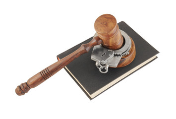 Judge's gavel and handcuffs on black legal book isolated