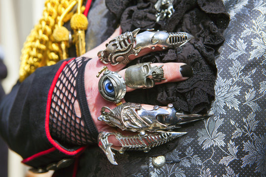 Man's hand in lacy glove and Gothic rings.
