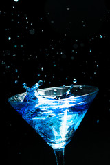 blue splashing cocktail on black