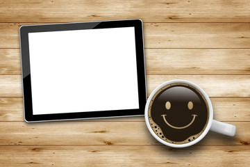 Tablet Pc mit Kaffee und Smiley auf Holz