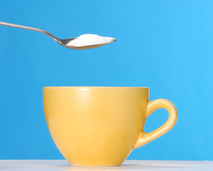 Sirviendo cucharada de azúcar en una taza de café,té.