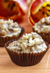 Toffee cupcakes with nuts on orange background