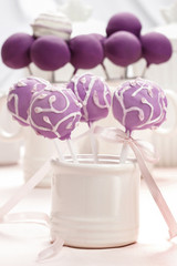 Lilac cake pops decorated lavishly decorated with icing.