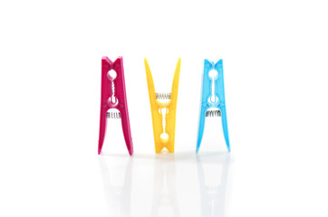 Three colored plastic clothes pegs side by side