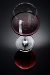 A glass filled with wine on a black table
