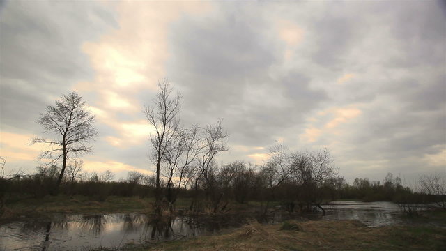 Cloudy weather with the small river. Time lapse