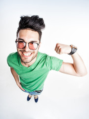 funny handsome man with hipster glasses showing muscles