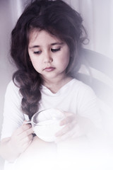 beautiful little girl with a cup of milk. close-up