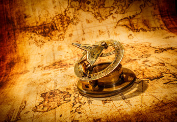 Vintage compass lies on an ancient world map.