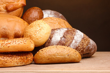 delicious bread on wooden table on brown background
