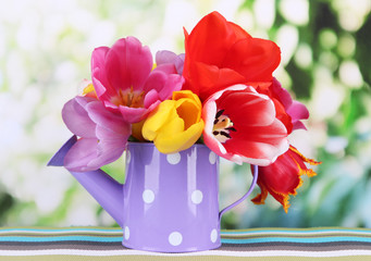 Beautiful tulips in bouquet on table on bright background