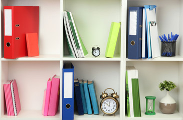 White office shelves with different stationery, close up
