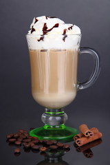 Layered coffee in glass on table on grey background