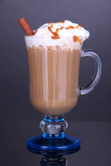 Layered coffee in glass on table on grey background