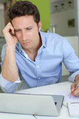 Fototapeta premium Man with doubtful look in front of laptop