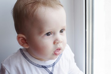 baby age of 7 months looks out the window