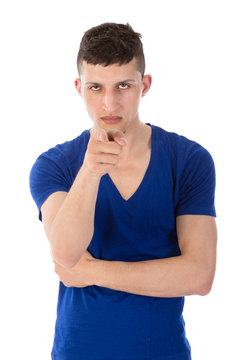 Angry young man pointing a finger towards you; isolated on white
