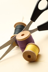 Thread bobbin and scissors on the white background