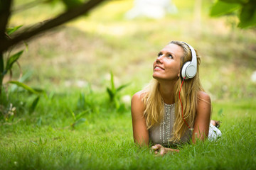 Lovely girl with headphones enjoying nature and music