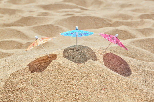 Small beach umbrellas on the beach near the sea.