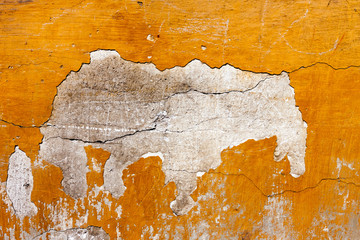 Badly damaged red plaster wall background