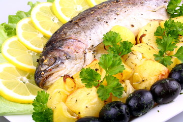 Baked trout with potatoes, olives, lemon and salad