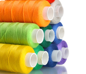 Pyramid of many-coloured bobbins of thread isolated on white