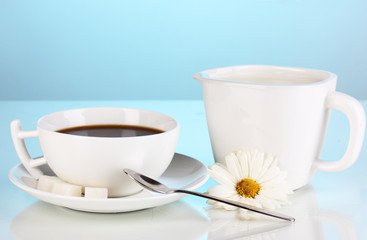 A cup of strong coffee and sweet cream on blue background