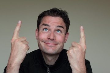 Handsome caucasian man pointing up with both hands