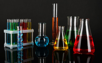 Test tubes with colorful liquids on dark grey background