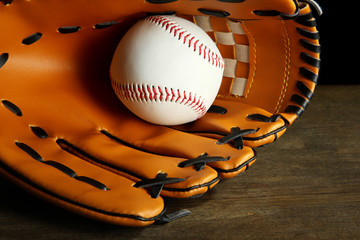 Obraz premium Baseball glove and ball on dark background